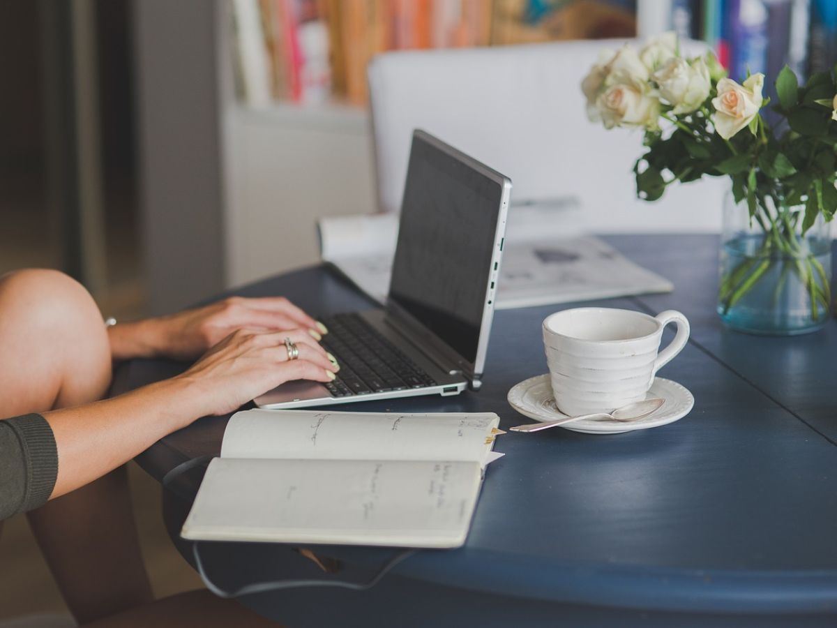 A person working on a laptop with a cup of coffee