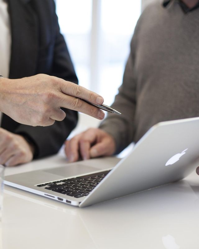 Two people reviewing work on a laptop
